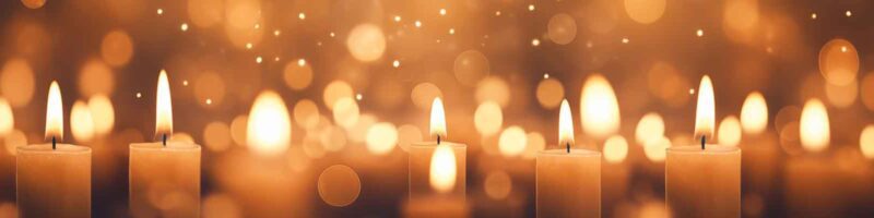 candles on a gold background with snow falling on new years eve